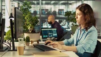 Close up of woman sitting at office desk, solving tasks during job shift. Office clerk doing email communication in workplace, researching data for company project, camera B video