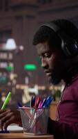 Vertical Black guy using study music to help with deep focus for academic success, consulting the campus university database to find reliable sources. Male college student fights for diploma. Camera A. video