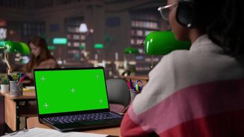 African american pupil uses green screen extracting citations from specialty books and other reliable academic sources, research tools within the university campus library. Self learning. Camera B. video