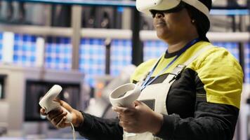Engineer working in industry 4.0 plant using virtual reality technology to check equipment. Smart factory employee using VR headset to manage and upgrade automation systems, camera B video