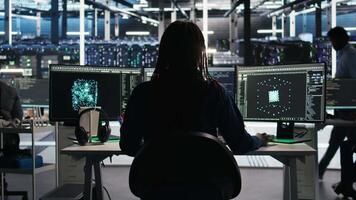 Server room programmer interpreting data analytics graphs, putting on headphones. Data center IT expert uses artificial intelligence tool showing system metrics, listening music, camera A video