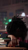 Vertical Person waking up african american girl in the university campus library, student falling asleep on stack of borrowed books. Tired and overwhelmed pupil tries to study all night. Camera A. video