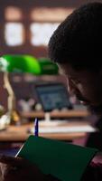 Vertical African american guy studies for a critical law exam and reading specialty books to complete class notes with reliable academic information. Studying in the library before the test. Camera A. video
