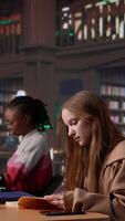 Vertical Noisy girl disturbing students at the library by speaking very loud on call, being rude and answering her phone in the study area. Disruptive annoying person asked to keep silence. Camera B. video