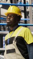 Vertical Man holding toolbox walking in factory, inspecting systems, ensuring machinery operates at optimal efficiency. Industry 4.0 plant repairman overseeing infrastructure, maintaining operations, camera B video