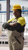 Vertical Portrait of jolly smart factory engineer calibrating high tech machinery and analyzing sensor data. Happy industrial plant worker troubleshooting assembly equipment, camera A video