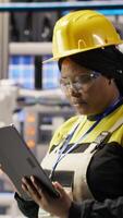Vertical Expert using tablet to conduct routine inspections in industry 4.0 plant producing renewable energy. Photovoltaics smart factory employee testing equipment using device, camera B video