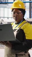 Vertical Solar panels factory engineer analyzing data from IoT sensors to refine equipment operational efficiency. Worker performing system diagnostics to reduce downtime in photovoltaic production, camera A video