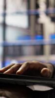 Vertical Close up of smart factory worker using laptop to test automated systems, monitoring production metrics. Industry 4.0 plant expert inspecting machinery to identify and fix malfunctions, camera A video