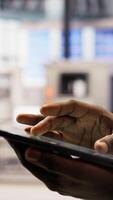 Vertical Close up of tablet used by smart factory specialist to implement automated workflows and control systems, computerizing operations. Industry 4.0 plant worker automates production with device, camera A video