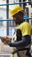Vertical Smart factory expert uses tablet to implement automated workflows and control systems, computerizing operations. Industry 4.0 plant technician integrates sensors into production using device, camera A video