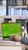 Vertical Engineer oversees solar panel production lines equipment using green screen laptop. Worker maintains photovoltaic assembly systems in automated industry 4.0 factory using chroma key notebook, camera A video