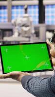 Vertical Solar panels plant technician uses green screen tablet to oversee systems. Photovoltaics plant employee uses software on chroma key device to maintain operations, camera A close up video