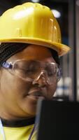 Vertical Solar panels plant technician uses laptop to oversee systems, ensuring machinery operates at optimal efficiency. Photovoltaics plant employee uses software on notebook to maintain operations, camera B video