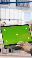 Vertical Smart factory mechanic testing automated systems using isolated screen laptop, doing maintenance. Industry 4.0 plant serviceman inspecting equipment using mockup notebook to identify errors, camera A video