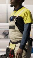 Vertical Man walking in industry 4.0 plant, taking note of modifications to make, providing technical support. Smart factory serviceman adding IoT sensors monitoring energy consumption, camera B video