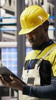 Vertical Smart factory repairman using tablet to analyze IoT sensors data before upgrading assembly lines. Industry 4.0 plant staff member performing system diagnostics to reduce errors, camera B video