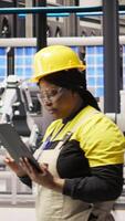 Vertical Industry 4.0 plant engineer following maintenance procedures to repair damages. Smart factory specialist analyzing data on laptop to predict conveyor belts and robotic arms failures, camera A video