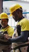 Vertical Smart factory engineering team brainstorming ways to implement automated workflows and control systems. Industry 4.0 plant teamworking colleagues integrates sensors into production, camera A video