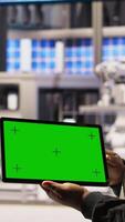 Vertical Smart factory specialist using green screen tablet to test automated systems to ensure reliability. Industry 4.0 plant technician using chroma key device to identify bottlenecks and optimize, camera A video