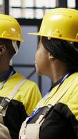 Vertical Smart factory manager overseeing work done by engineer calibrating high tech machinery and analyzing sensor data. Team leader supervising engineer troubleshooting assembly equipment, camera B video