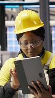 Vertical Industry 4.0 plant engineer following maintenance procedures to repair damages. Smart factory specialist analyzing data on laptop to predict conveyor belts and robotic arms failures, camera B video
