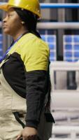 Vertical Smart factory mechanic installing automated workflows control systems, computerizing operations. Repairman walking in industry 4.0 plant with toolbox, integrating sensors into production, camera B video