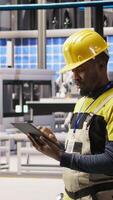 Vertical Smart factory specialist testing automated systems, monitoring operational integrity. Industry 4.0 plant technician inspecting equipment to identify and repair damages, camera A video