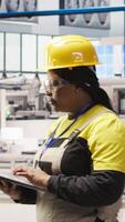 Vertical Solar panels factory engineer analyzes performance data with laptop to predict equipment failures. Photovoltaics plant worker following maintenance procedures to minimize downtime, camera A video