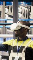 Vertical Smart factory specialist using virtual reality simulation to predict equipment failures. Industry 4.0 plant engineer using VR headset to follow maintenance procedures and repair damages, camera B video