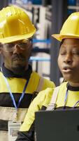 Vertical Engineering team working together, overseeing solar panel production lines equipment. Teamworking colleagues maintaining photovoltaic assembly systems in automated industry 4.0 factory, camera B video