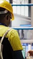 Vertical Smart factory engineering team using laptop to analyze IoT sensors data, refining equipment efficiency. Teamworking industrial plant colleagues perform system diagnostics to reduce downtime, camera B video