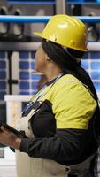 Vertical Technician overseeing solar energy installation process, troubleshooting automated machinery, calibrating robotic arms in renewable energy manufacturing facility, camera B video