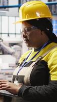 Vertical Smart factory specialist typing on laptop keyboard, testing automated systems to ensure reliability. Industry 4.0 plant technician using notebook to identify bottlenecks and optimize, camera A video