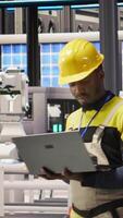 Vertical Engineer in smart factory implementing renewable energy solutions by integrating solar technology with automated assembly systems, enhancing production efficiency, camera A video