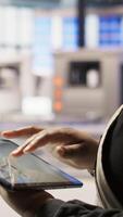Vertical Close up of engineer in industry 4.0 plant designing robotic production lines using CAD application on tablet. Smart factory specialist uses software to optimize floor layouts, camera A video