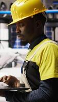 Vertical Technician in industrial plant overseeing solar energy installation process, troubleshooting errors. Renewable energy manufacturing facility employee calibrating automated robotic arms, camera A video