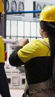 Vertical IT staff members overseeing solar panel production lines equipment. Coworkers doing brainstorming, maintaining photovoltaic assembly systems in automated industry 4.0 factory, camera A video