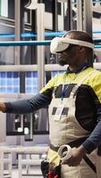 Vertical Smart factory specialist using virtual reality simulation to predict equipment failures. Industry 4.0 plant engineer using VR headset to follow maintenance procedures and repair damages, camera A video