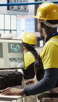 Vertical Engineer overseeing solar panel production lines equipment using PC software. Worker maintaining photovoltaic assembly systems in automated industry 4.0 factory using computer, camera A video