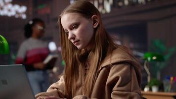 Female student makes final preparations for her university periodicals, combining research on books from the academy database and handwritten notes. Educated girl studying. Camera A. video