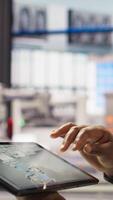 Vertical Industry 4.0 industrial plant engineer designs new robotic machines using CAD application on tablet. Smart factory worker optimizing equipment layouts on facility floor, camera A close up video