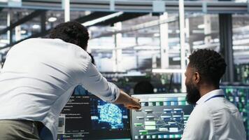 Pleased data center manager praising work done by engineer using neural network models to configure hardware. Supervisor congratulating employee for successfully using AI to optimize system, camera B video