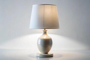 Stylish white ceramic table lamp with soft lighting, showcasing a minimalist design with a classic lampshade for contemporary interiors photo