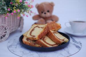 At the center is a black plate filled with slices of marble cake photo