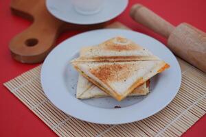 a plate of toasted sandwich triangles neatly stacked on a white plate photo