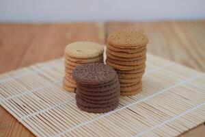 Three stacks of intricately patterned cookies are beautifully arranged on a bamboo mat photo