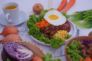 a beautifully arranged healthy meal on a white plate, placed on a marble-textured surface photo