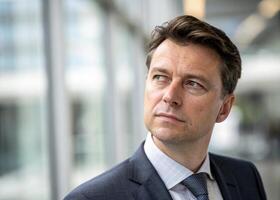 a man in a suit and tie looking off the side photo