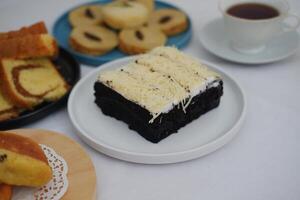 The cake is neatly sliced into several square portions photo